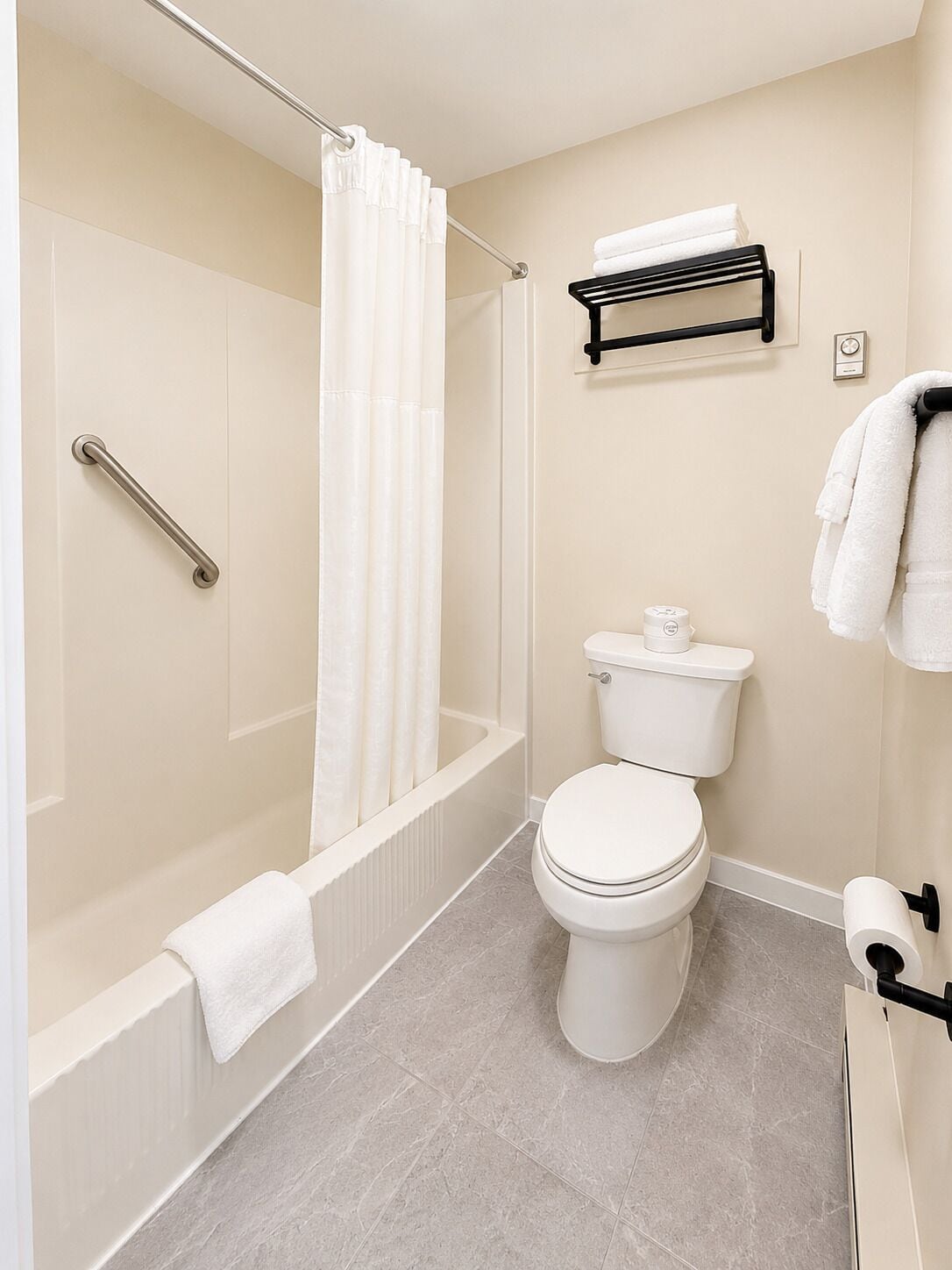 A bathroom with a bathtub, toilet, and shower curtain.