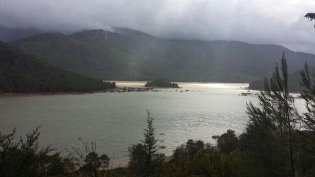 Un lago rodeado de montañas y árboles.