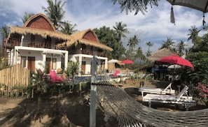 Et resort med bindingsværkshuse, et poolområde og liggestole.