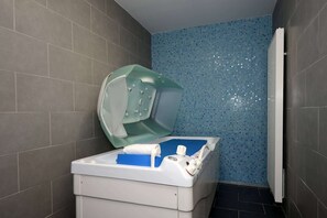 Une salle de bain avec une baignoire, une douche et un mur carrelé.