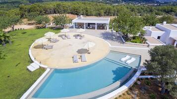 Een buitenzwembad, ligstoelen bij het zwembad