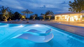 Una piscina al aire libre, tumbonas