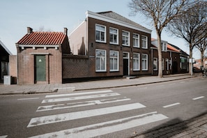 A two-story brick building with a flat roof and multiple windows. - De Zilte Melis (Meliskerke)