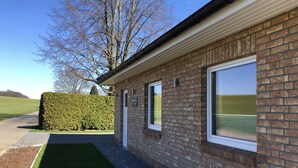 Un bâtiment en briques doté de grandes fenêtres et d’un chemin pavé qui y mène.