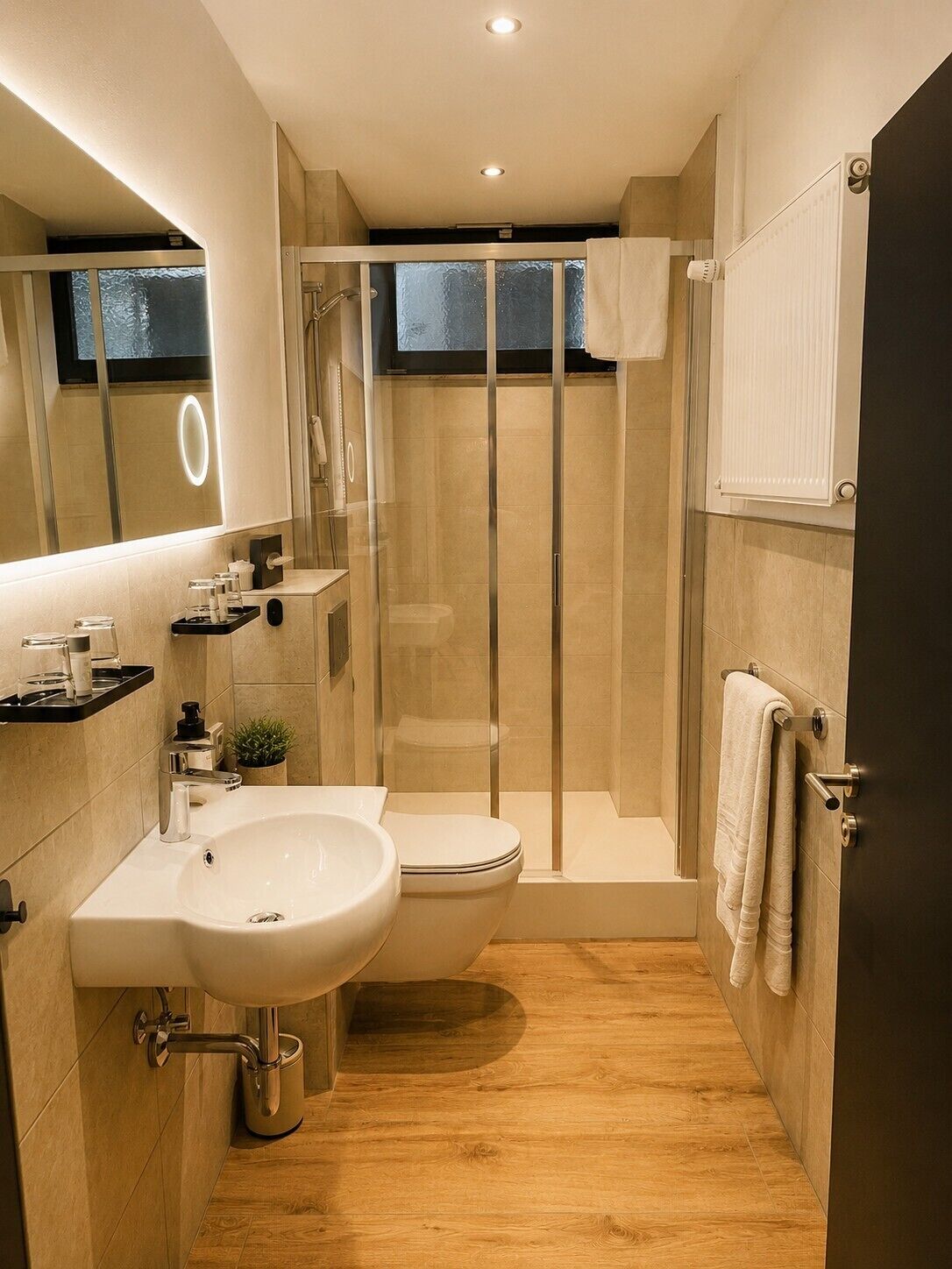 Une salle de bain moderne avec une douche à parois de verre, un lavabo blanc et des toilettes.