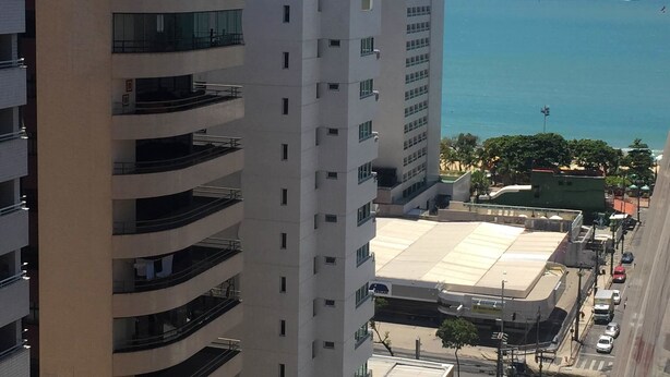 Un edificio alto con varios balcones que dan a la costa.