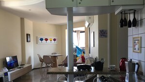 Una cocina compacta con comedor, microondas, estufa y pileta.