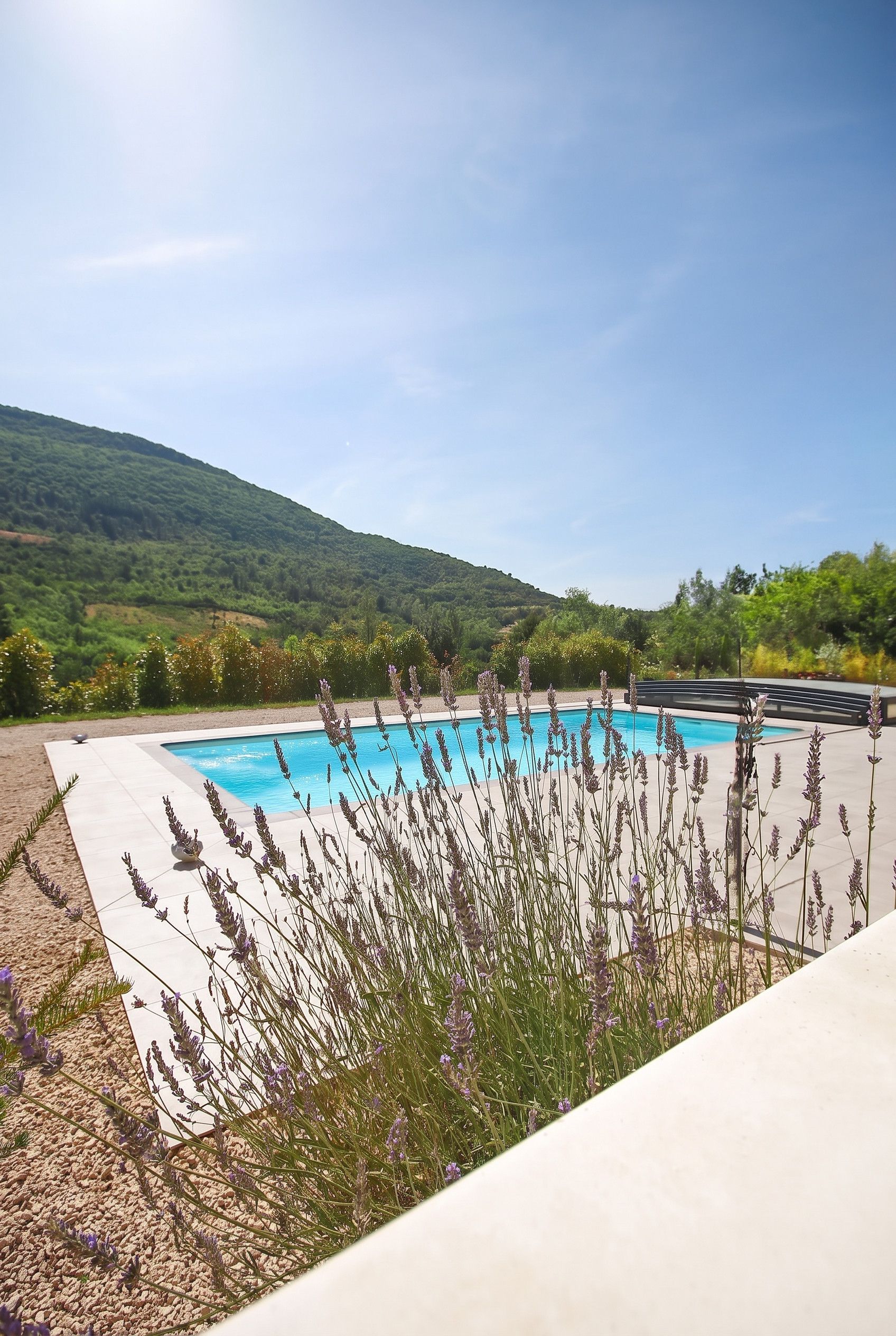 Une piscine avec vue sur une colline verdoyante.