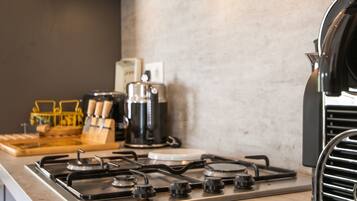 Une cuisine équipée d’une cuisinière à gaz, d’une machine à café et d’un gril.
