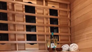 A wooden sauna with a shelf holding bottles and towels. - Vollie House (Thornhill)