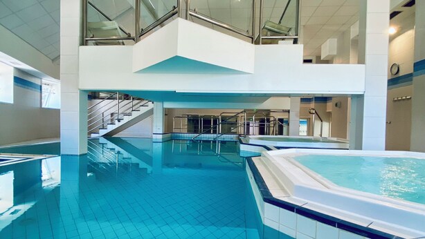 An indoor swimming pool with a tiled floor, a hot tub, and a glass railing overlooking the pool. - La Résidence Le Grand Tétras (Ax-les-Thermes)