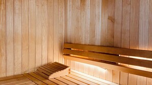A sauna with wooden benches and a bench with a backrest. - La Résidence Le Grand Tétras (Ax-les-Thermes)