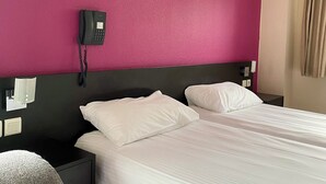 A hotel room with two beds, a black headboard, a phone on the wall, and a nightstand with a lamp. - La Résidence Le Grand Tétras (Ax-les-Thermes)