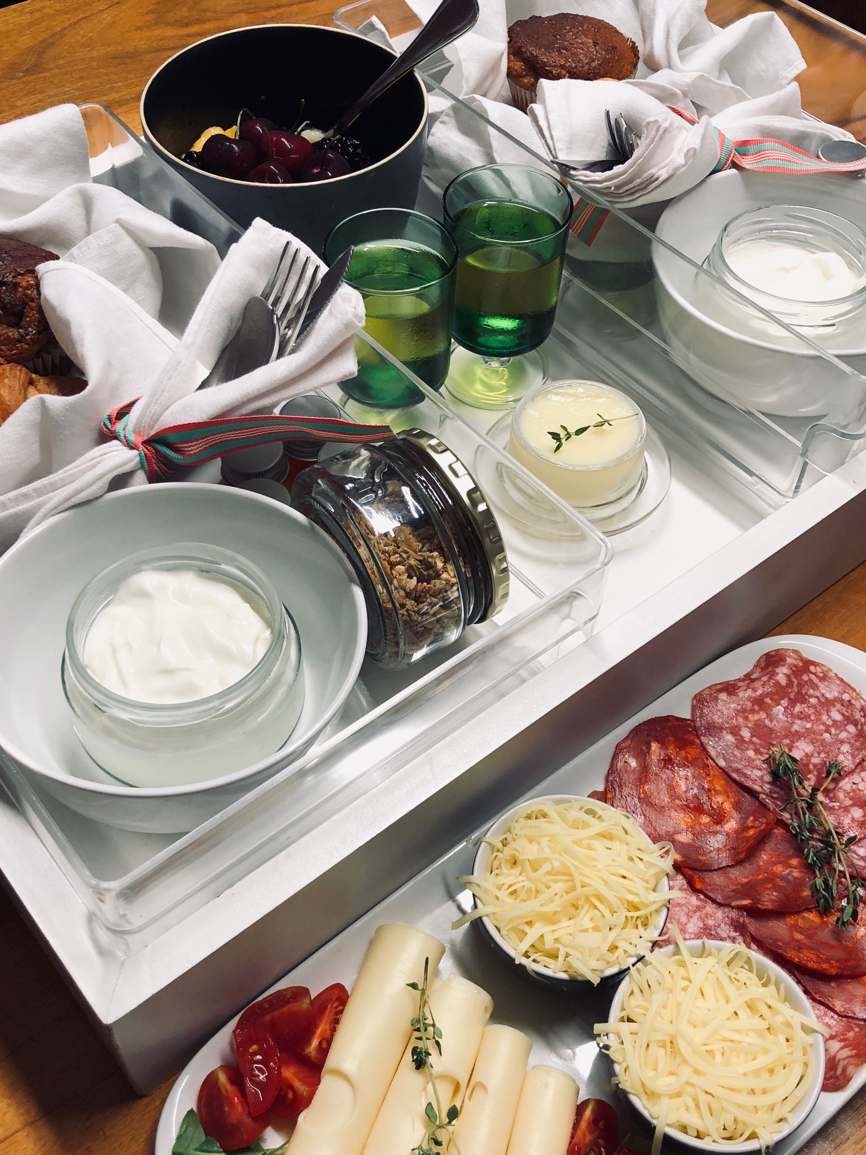 Una bandeja con diversos alimentos, como tomates en rodajas, queso y embutidos.