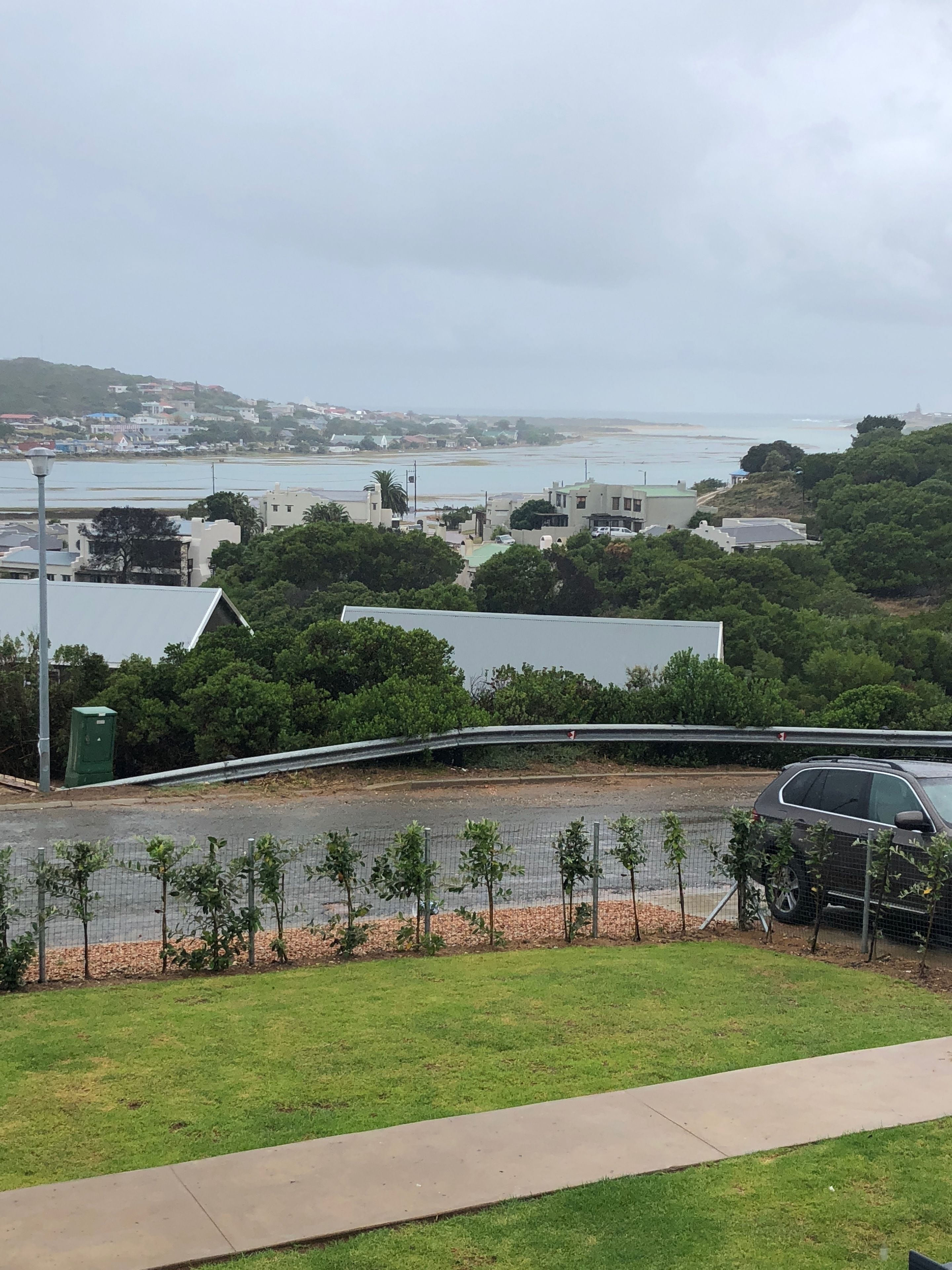 A coastal town with buildings, a road, and a view of the sea.