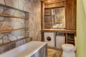 Bathtub, hair dryer, towels, toilet paper