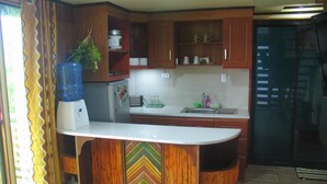 Una cocina con armarios de madera, una isla integrada, un refrigerador y un dispensador de agua.