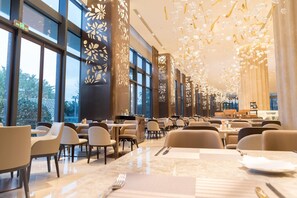 A spacious restaurant with high ceilings, large windows, and modern decor. - Wyndham Grand Plaza Royale Yuzhou Xiamen (Xiamen)