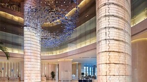 A spacious lobby with high ceilings, large columns, and a modern chandelier. - Wyndham Grand Plaza Royale Yuzhou Xiamen (Xiamen)