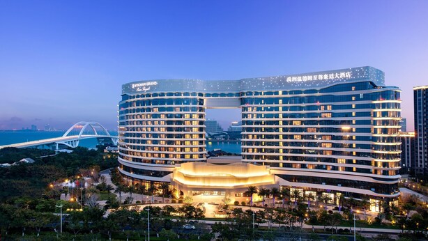 A modern hotel with a curved facade, multiple floors, and a central atrium. - Wyndham Grand Plaza Royale Yuzhou Xiamen (Xiamen)