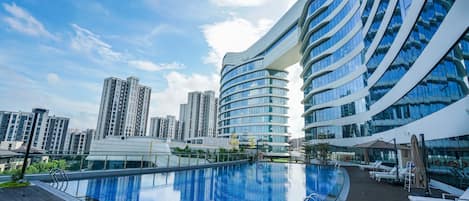 Una piscina al aire libre, tumbonas