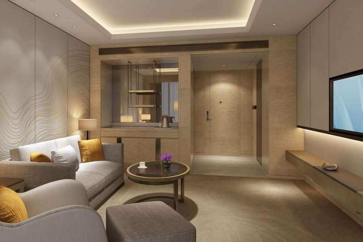 A modern living room with a sofa, coffee table, and a TV mounted on the wall.