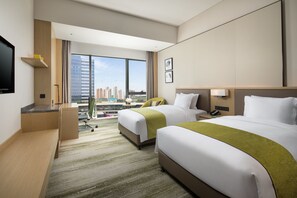 A hotel room with two beds, a desk, a flat-screen TV, and a large window with a city view. - Holiday Inn Zhengzhou Riverside by IHG (Zhengzhou)