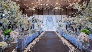 A wedding venue with a central aisle, floral arrangements, and a backdrop with a year displayed. - Holiday Inn Zhengzhou Riverside by IHG (Zhengzhou)