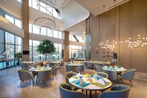 A spacious indoor dining area with high ceilings, large windows, and modern lighting fixtures. - Holiday Inn Zhengzhou Riverside by IHG (Zhengzhou)