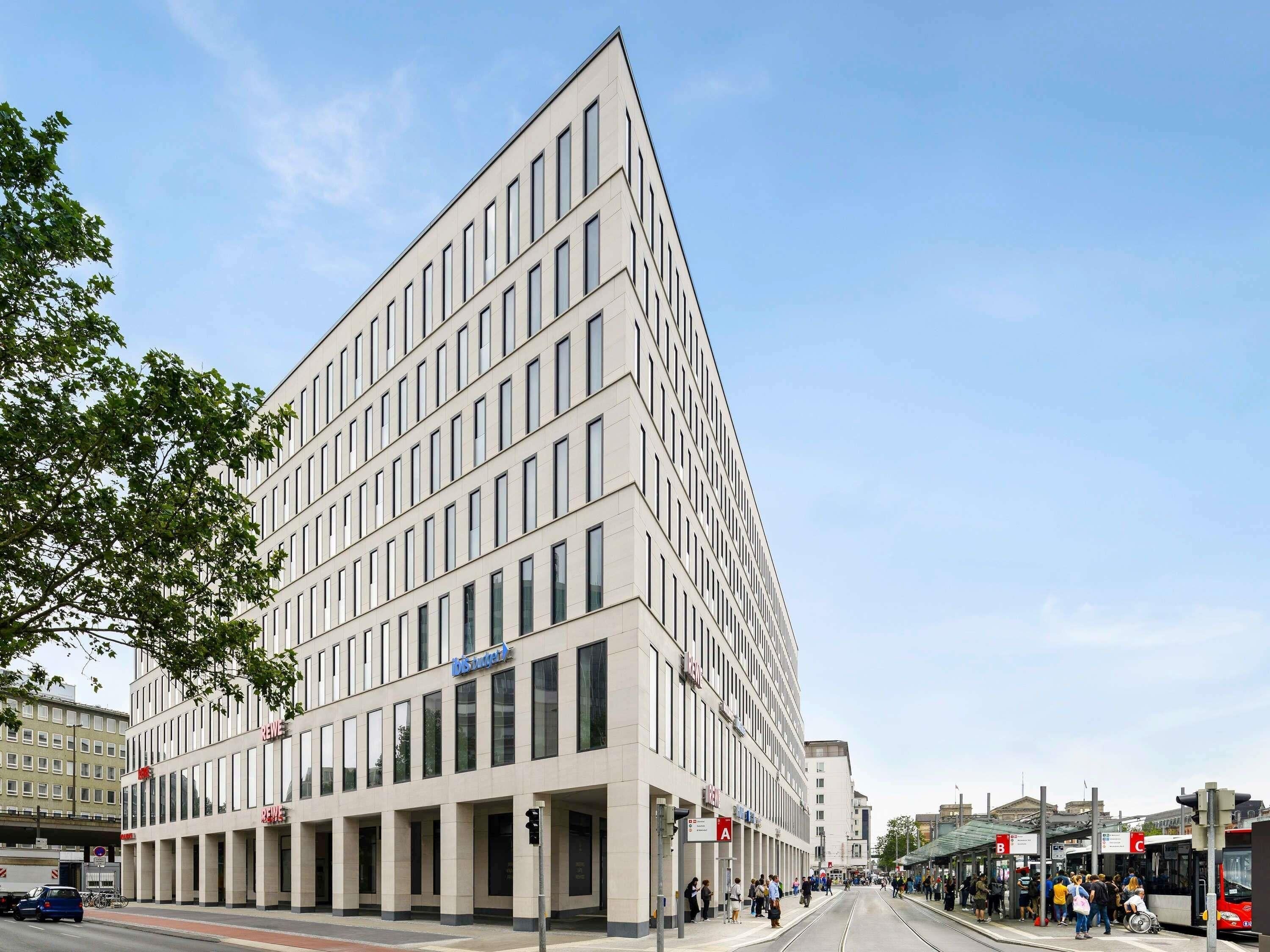 A modern building with a flat facade, large windows, and a prominent entrance.