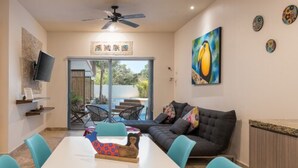 A modern living room with a sofa, a dining table with chairs, a ceiling fan, and artwork on the walls. - Paramar Terra by Tulumeando (Tulum)