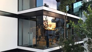 Un edificio moderno con amplios ventanales y un balcón con vistas a un gimnasio.
