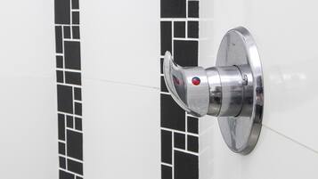 A bathroom door with a metallic handle and a red accent.