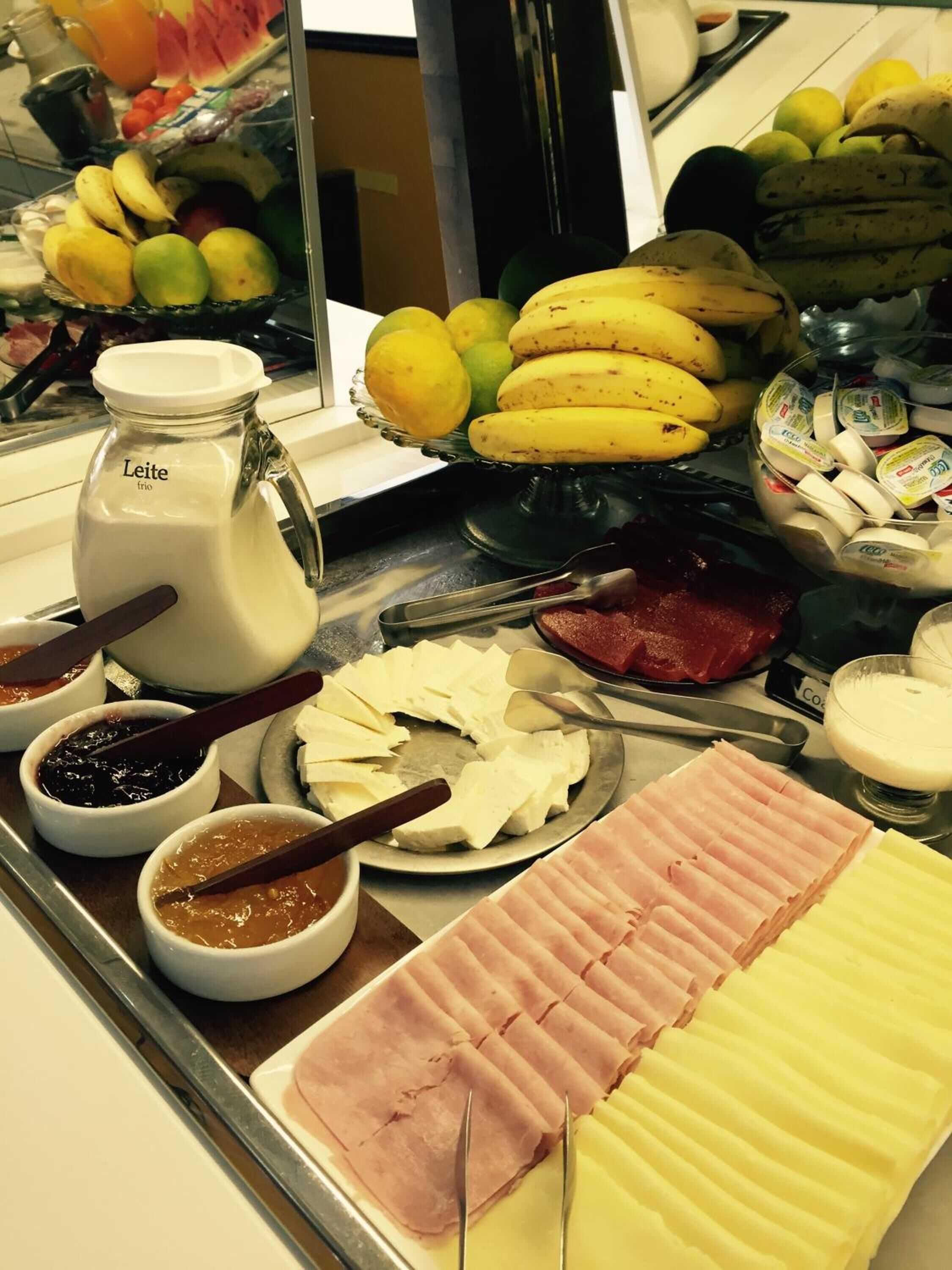 A buffet with various food items including fruits, cheeses, and meats.