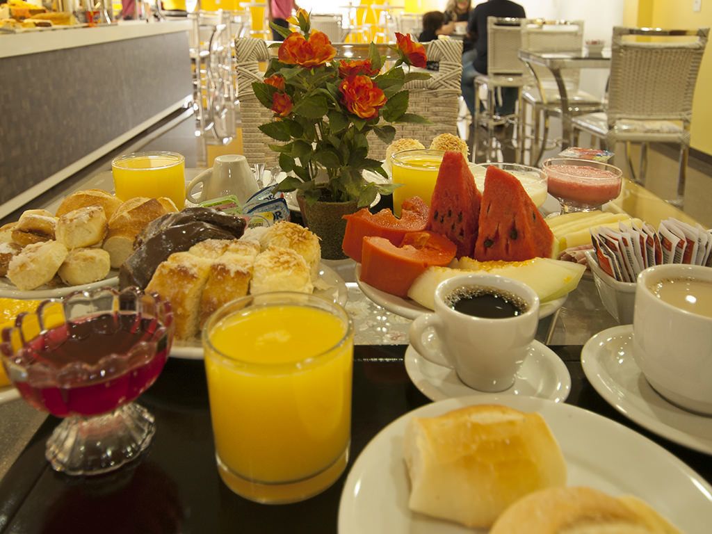 Un bufé de desayuno con diversos pasteles, frutas y bebidas.