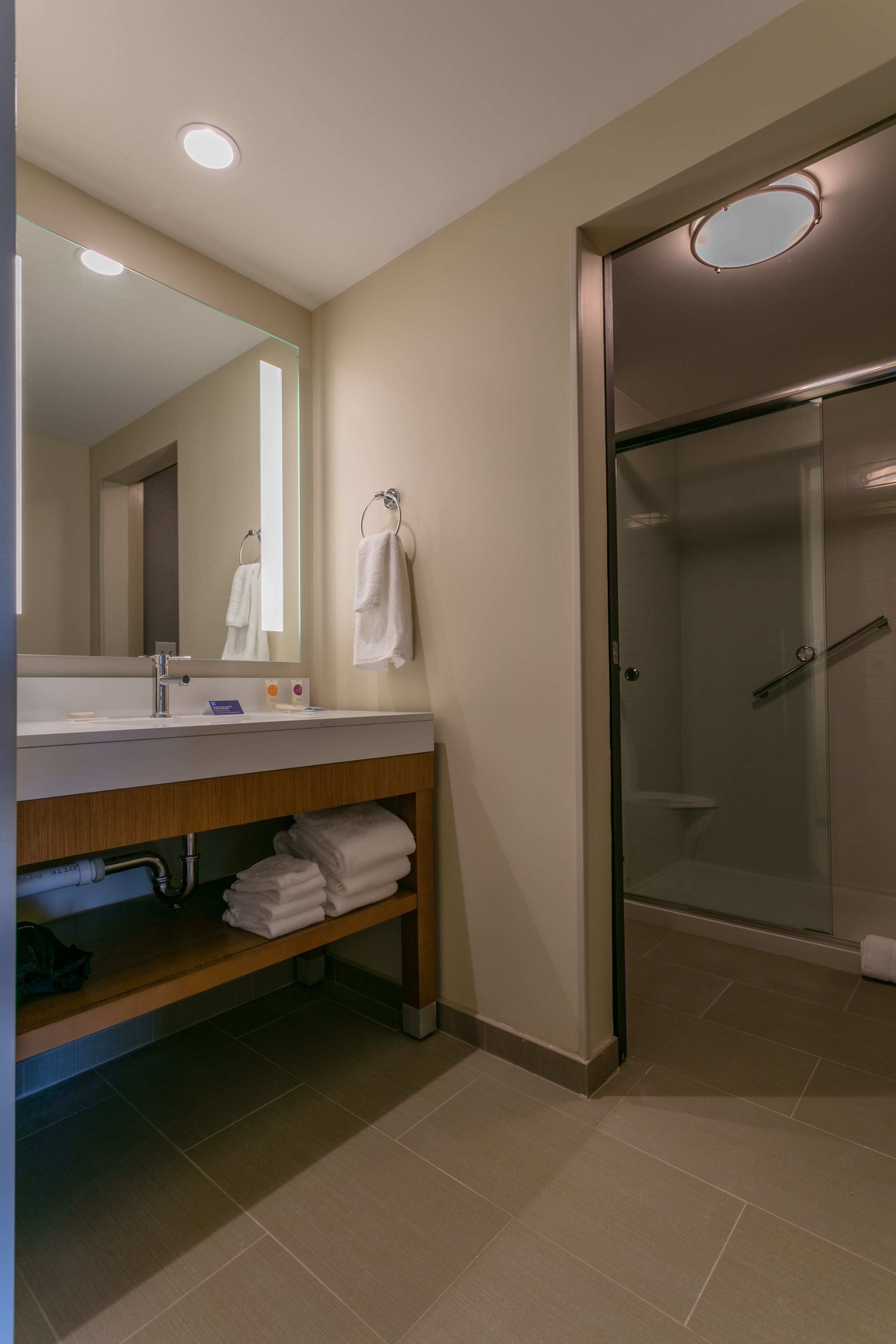 Un bagno moderno con lavabo, specchio e cabina doccia in vetro.