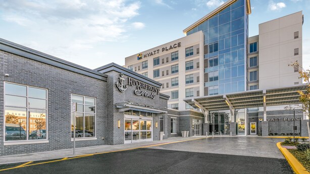 A hotel entrance with a modern design, featuring a glass facade and a covered entrance area. - Hyatt Place Wilmington Riverfront (Wilmington)