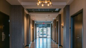 A long, well-lit hallway with wooden flooring and modern lighting fixtures. - Hyatt Place Wilmington Riverfront (Wilmington)
