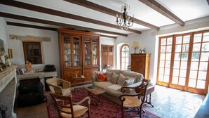 A traditional living room with a sofa, two armchairs, a wooden cabinet, and a large window. - Authentic farmhouse in Saint Remy de Provence (Saint-Rémy-de-Provence)