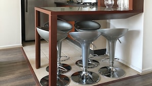 A modern kitchen with a central island, stainless steel appliances, and a wooden cabinet. - Amistar Apartments (Santiago)