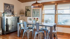 A dining area with a wooden ceiling, a table with chairs, a hanging light fixture, and artwork on the walls. - Minutes to Galena.  Bird Cottage @ Sorriso Vineyard Galena Illinois (Galena)