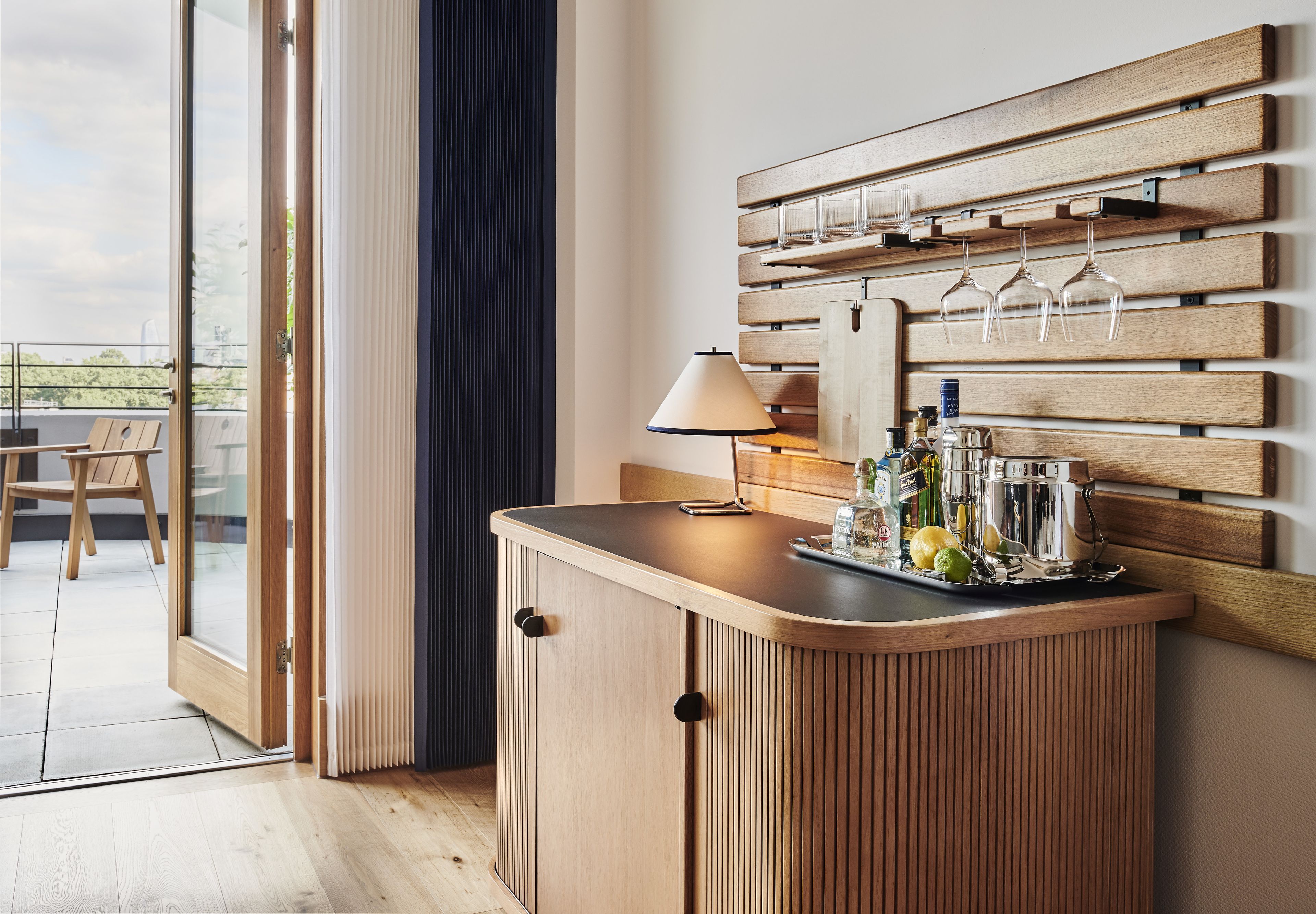 A wooden bar area with a glass door leading to an outdoor seating area.