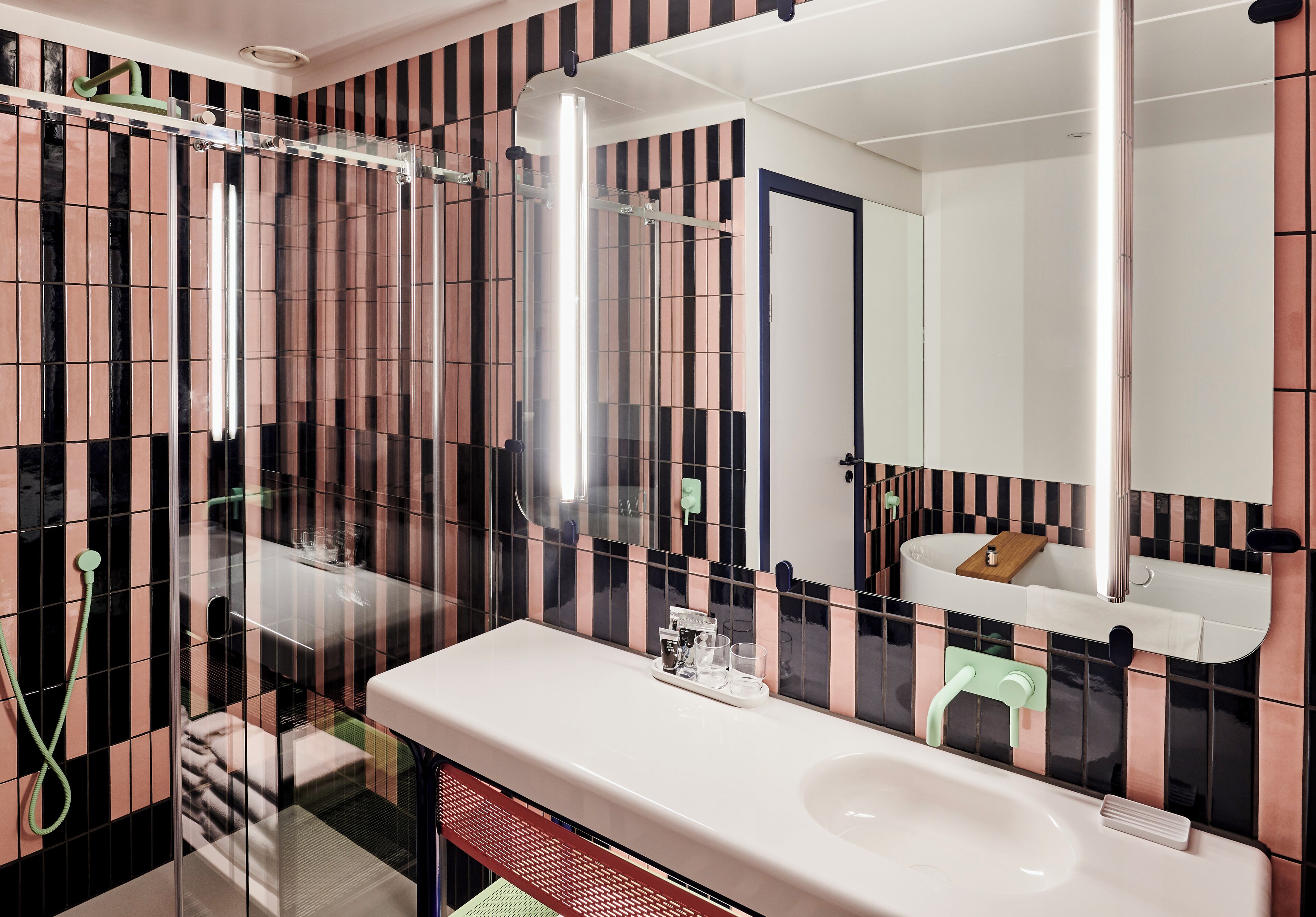 A bathroom with a white sink, a mirror, and a shower area.
