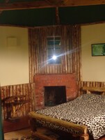 Una habitación rústica con una cama de madera, una chimenea y un banco de madera.