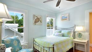 A bedroom with a bed, a chair, a nightstand, and a ceiling fan. - STARS AND STRIPES ~ Magnificent Home Located In The Heart of Old Town! (Key West)