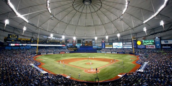 A large indoor baseball stadium with multiple levels of seating, a central field, and various advertisements on the walls. - Express inn and suites (Clearwater)