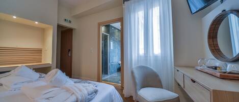 Une chambre d’hôtel comprenant un lit, un bureau avec un miroir, une chaise et un appareil de climatisation.
