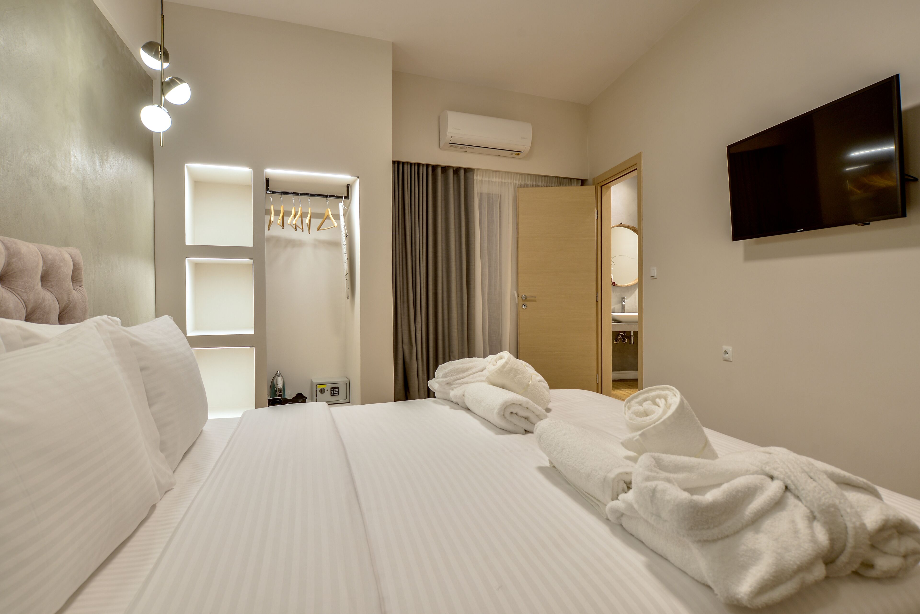 Une chambre d’hôtel équipée d’un lit, d’une télévision, d’une armoire et d’un appareil de climatisation.