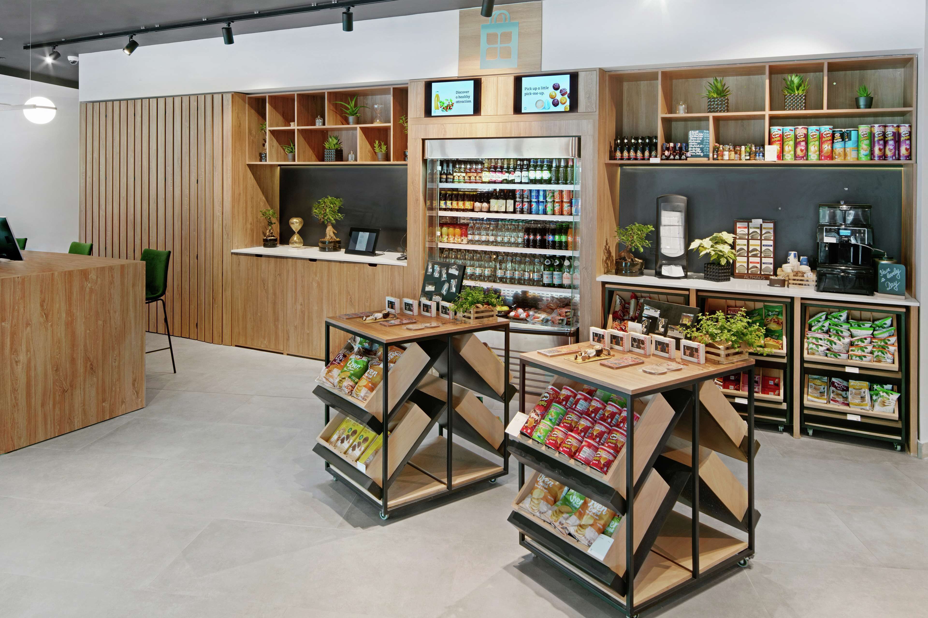 A modern retail space with wooden shelving, a coffee machine, and various packaged goods.