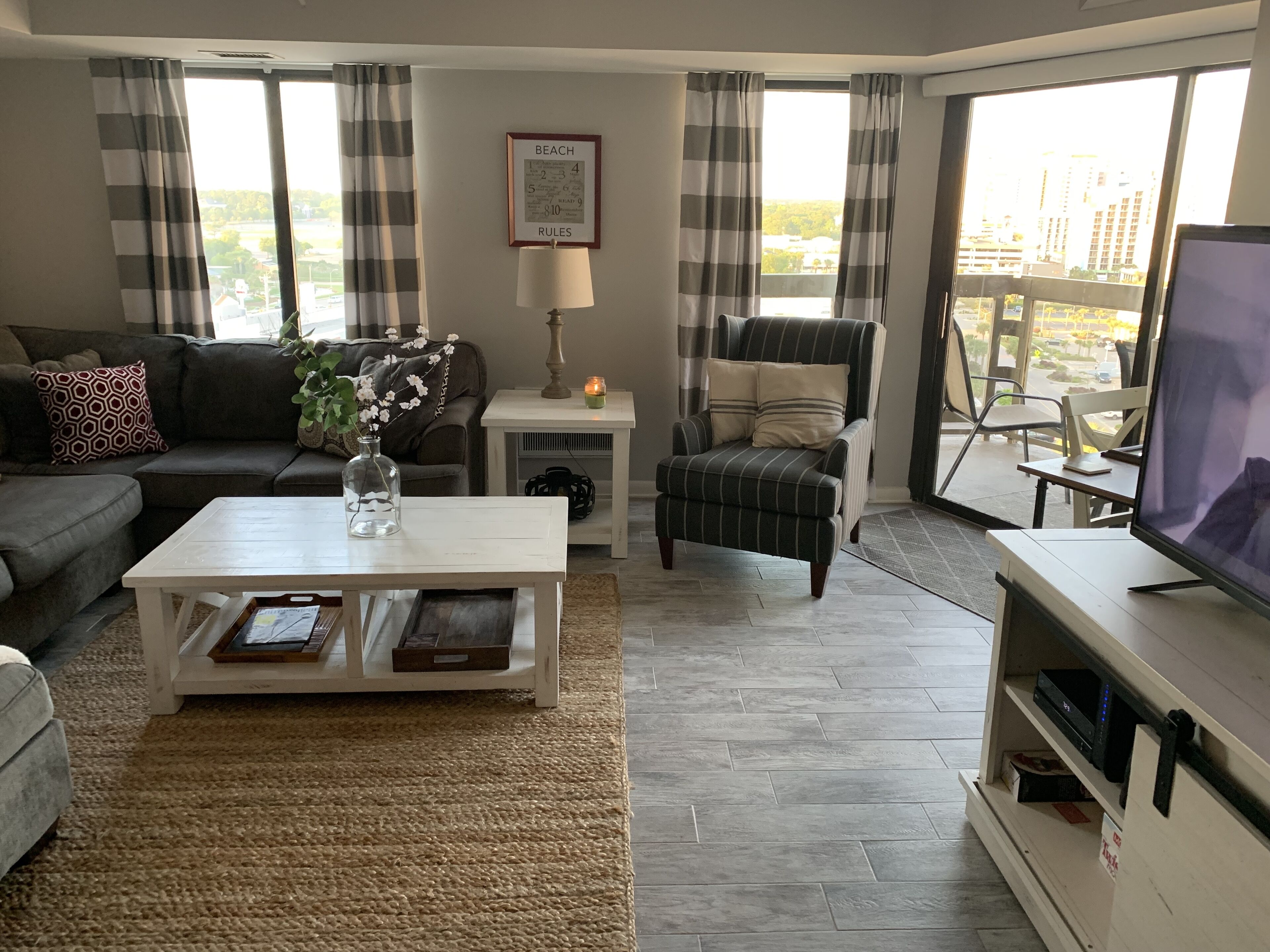 Een woonkamer met een bank, fauteuil, salontafel en een televisie.